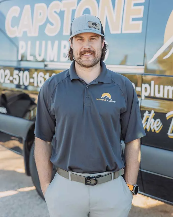 Capstone Plumbing technician in uniform beside the branded service van, serving the North Valley, AZ