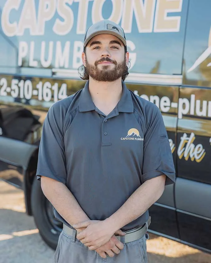 Capstone Plumbing technician in uniform in front of the branded service van in Cave Creek, AZ